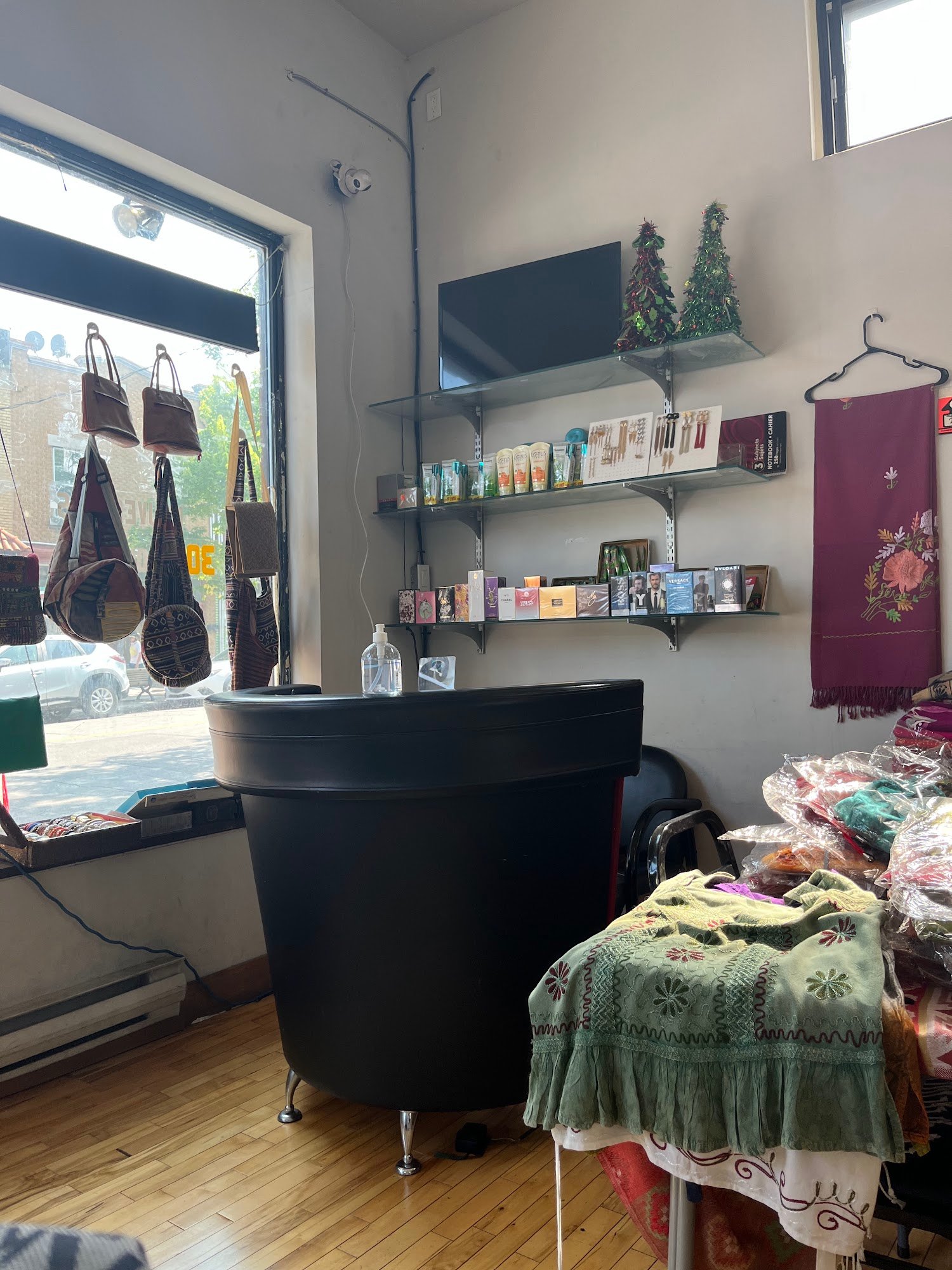 Coin réception et boutique du salon Neelam : sacs faits main dans la vitrine, tablettes de produits de beauté.